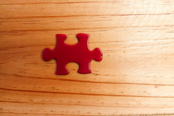 Faltando quebra-cabeça vermelho na mesa de madeira. Espaço de cópia
 - Foto, Imagem
