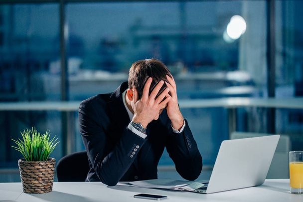 Stressed businessman having problems and headache at work - Foto, afbeelding