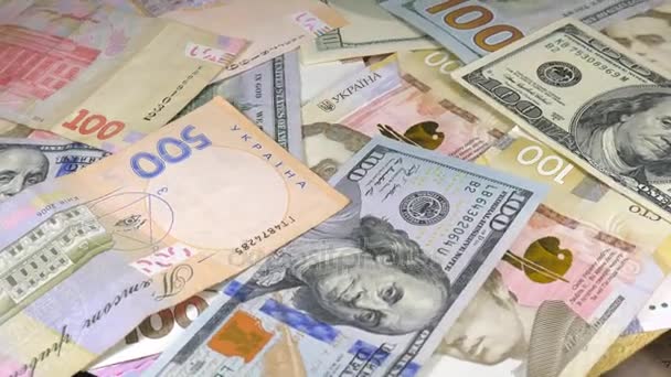 El dinero rota sobre la mesa. Denominaciones. Dólar y hryvnia
 - Imágenes, Vídeo