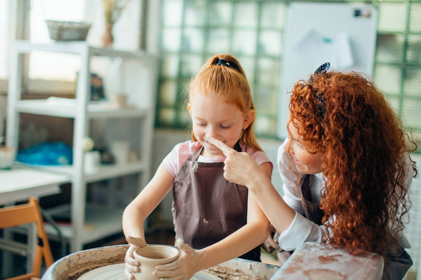 redhead sisters make a pitcher of a pottery wheel - Foto, immagini