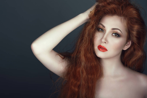 Bliska portret przepiękny czerwony zatytułowany kobiety z piękny makijaż trzyma ją za rękę w jej włosy - Zdjęcie, obraz
