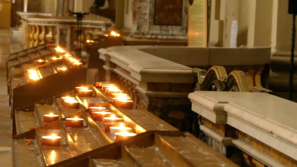 Katolikus templomban ünnepi gyertyák égnek a fém állványok - Felvétel, videó