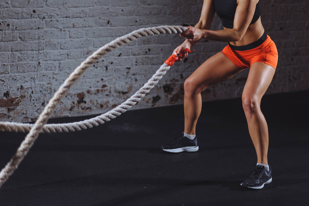 Powerful woman do workout with battle ropes in gym - Zdjęcie, obraz