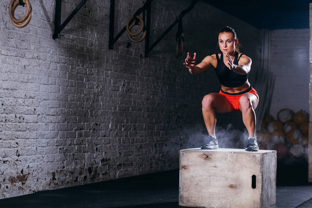 woman jumping box. Fitness woman doing box jump workout at cross fit gym. - Fotografie, Obrázek