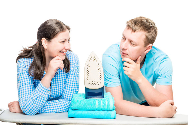 portrait of couple on background of ironing board, iron and towe - Photo, Image