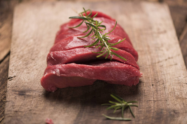 Raw beef steak on a dark wooden table. - Фото, зображення