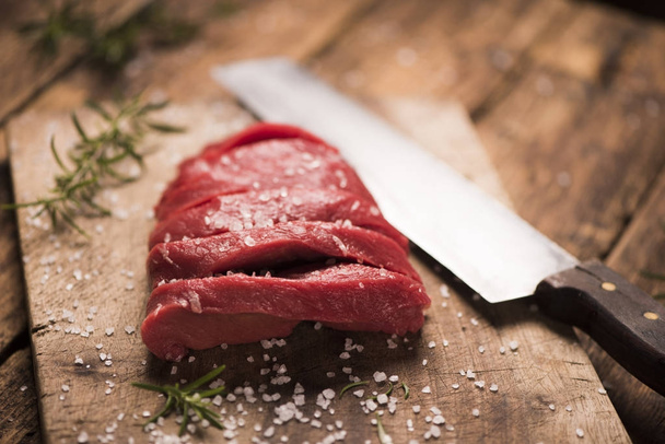 Raw beef steak on a dark wooden table. - 写真・画像