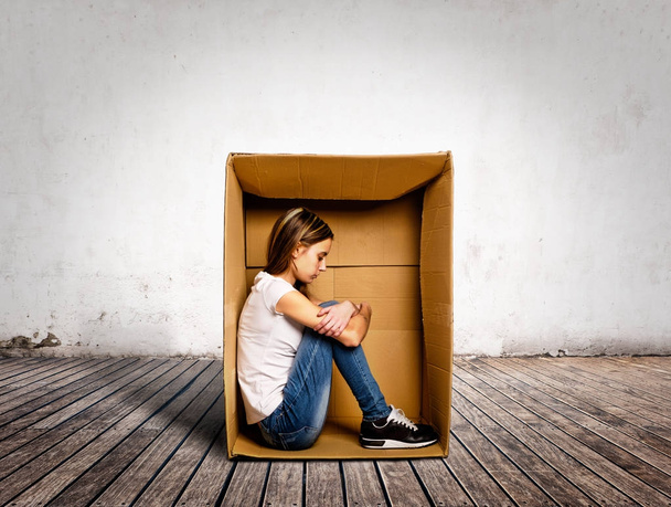 sad young woman inside a Box on a room - Foto, afbeelding
