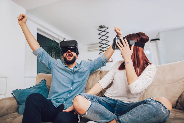 Fiatal férfi és egy nő alkalmi ruhákat viselnek, a virtuális valóság szemüveg figyeli, és bemutatja képzelni keresztül Vr kamera, a technológia és az innováció fogalma - Fotó, kép