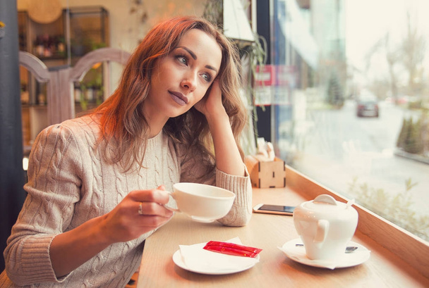 Thoughtful woman having coffee alone - Foto, Imagem
