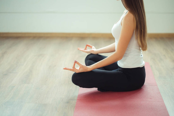 Young woman meditates while practicing yoga - Φωτογραφία, εικόνα