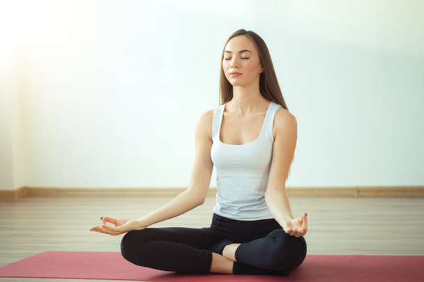 Young woman meditates while practicing yoga - Fotó, kép