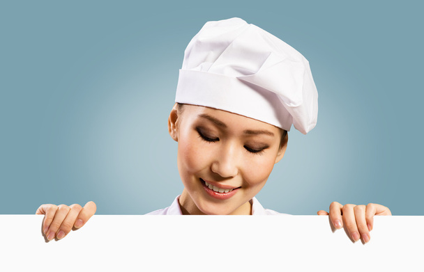 Female chef holding a poster for text - Valokuva, kuva