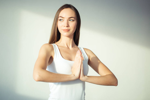 woman practicing yoga and meditation, holding palms together in namaste mudra - 写真・画像