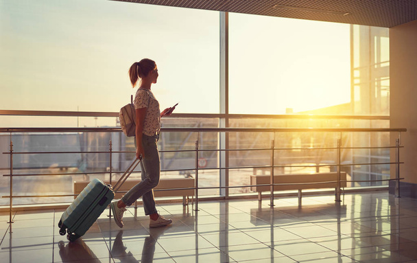 giovane donna va in aeroporto alla finestra con valigia in attesa
 - Foto, immagini