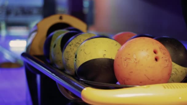 Person nimmt Bowlingkugeln mit Kegelbahn im Hintergrund - Filmmaterial, Video