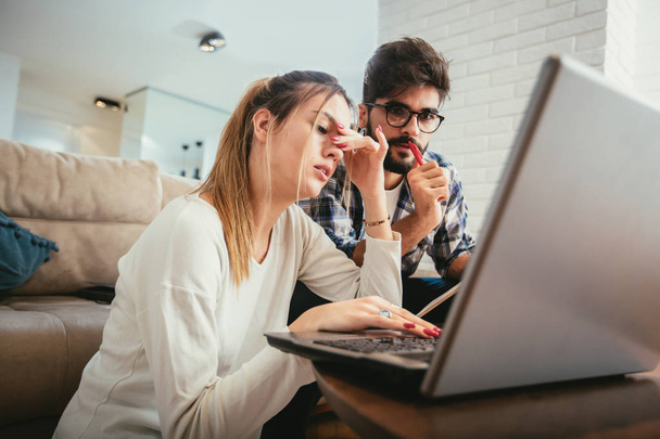 Γυναίκα και ο άνθρωπος κάνει γραφειοκρατία μαζί, πληρώνουν φόρους σε απευθείας σύνδεση στο φορητό υπολογιστή - Φωτογραφία, εικόνα