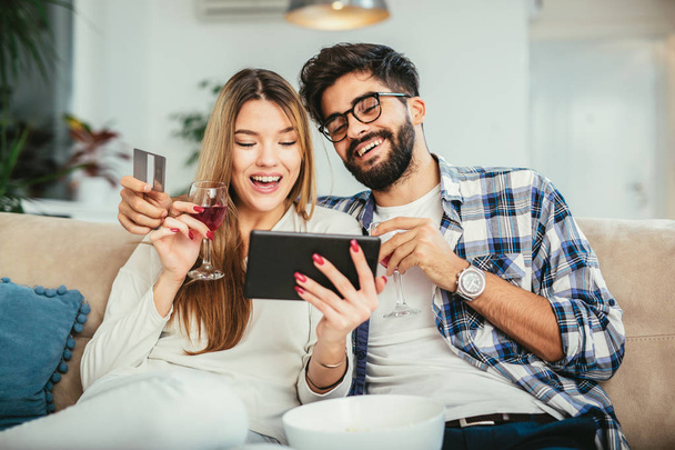技術、オンライン ショッピング、人々 コンセプト - タブレット pc コンピューターとクレジット カード家で幸せなカップルの笑顔 - 写真・画像