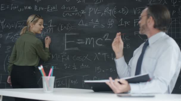 4K Portrait smiling academic man and woman studying math formulas on blackboard - Πλάνα, βίντεο
