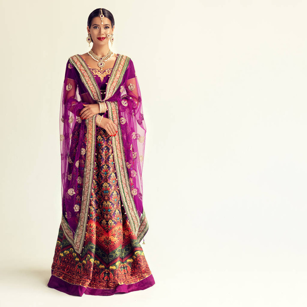 Портрет красивой индийской девушки. Молодая индуистка-модель с ювелирным набором кундан. Традиционные индийские костюмы lehenga choli или сари
 - Фото, изображение
