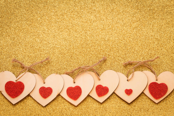 Feliz día de San Valentín / corazones decorativos ocasionales sobre un fondo de oro brillante con un lugar para una inscripción
 - Foto, imagen