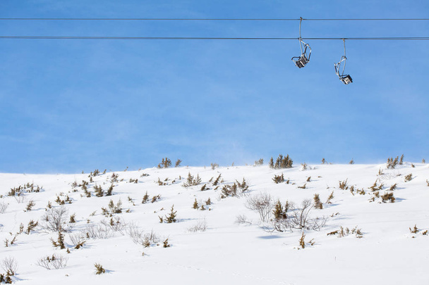 ski chair lift against blue sky - Fotó, kép