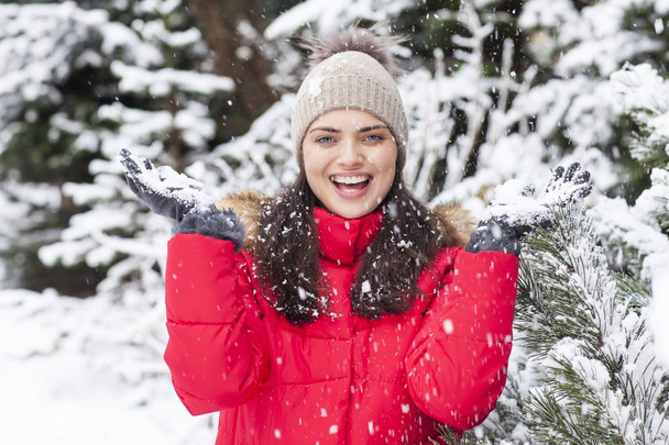 Щаслива молода жінка кидає сніг
.  - Фото, зображення