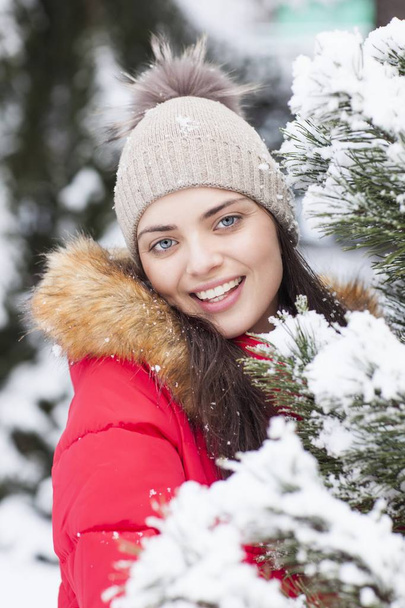 Güzel kadın parkta kar yağışı sırasında mutludur. - Fotoğraf, Görsel