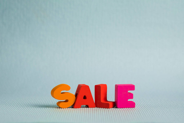 Sale colorful wooden text on blue background with copy space, sh - 写真・画像