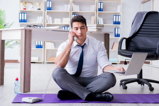 Ο άνθρωπος διαλογίζεται στο γραφείο για να αντιμετωπίσει το άγχος - Φωτογραφία, εικόνα