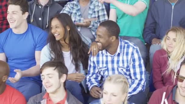 4K Crowd cheering on their team at sports event, focus on young couple - Footage, Video
