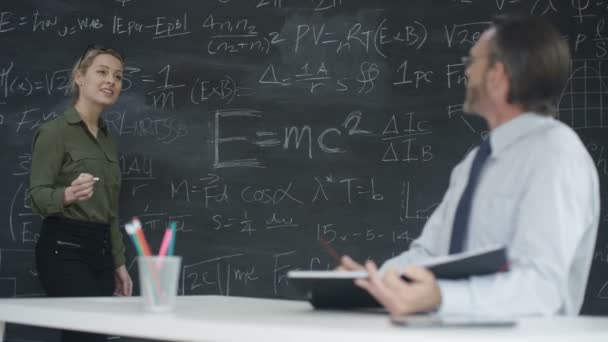 4K Portrait smiling academic man and woman studying math formulas on blackboard - Πλάνα, βίντεο