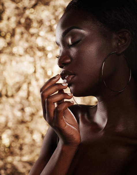 Fashion studio portrait of an extraordinary beautiful african american model with closed eyes  over golden background - Foto, Imagen