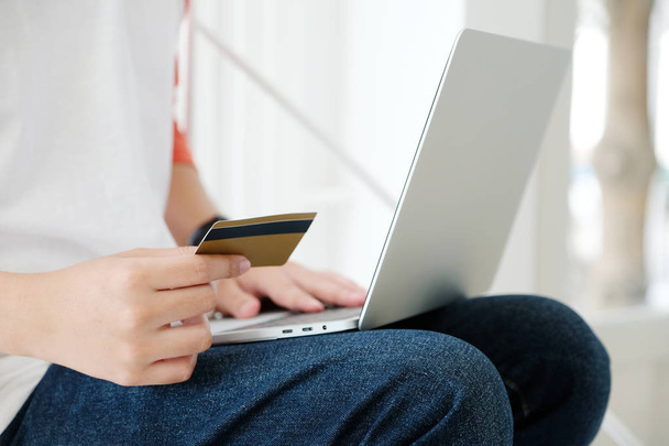 Man holding credit card and using laptop computer to shopping on - Foto, Imagem