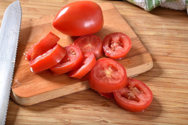 Sliced roma tomatoes on a cutting board - Photo, image