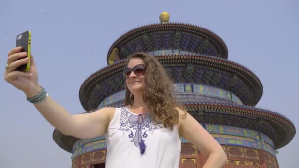 Sonnenbrille tragende Frau macht Selfie am Himmelstempel - Filmmaterial, Video