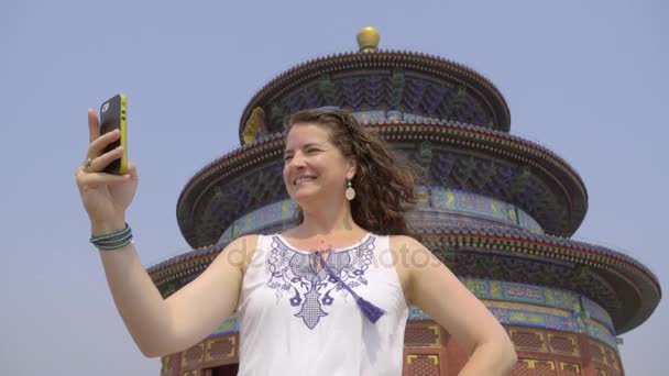 Vrouwelijke toerist neemt een selfie op de tempel van de hemel - Video
