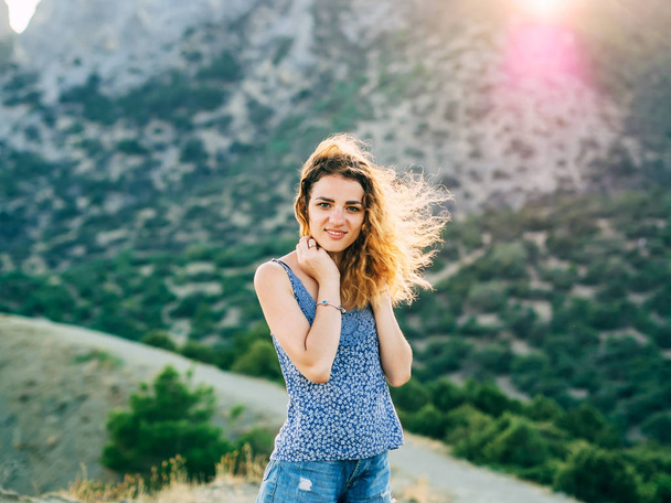 šťastný mladý model dívka s krásným úsměvem a dlouhými vlasy, pózuje v přírodě při západu slunce - Fotografie, Obrázek