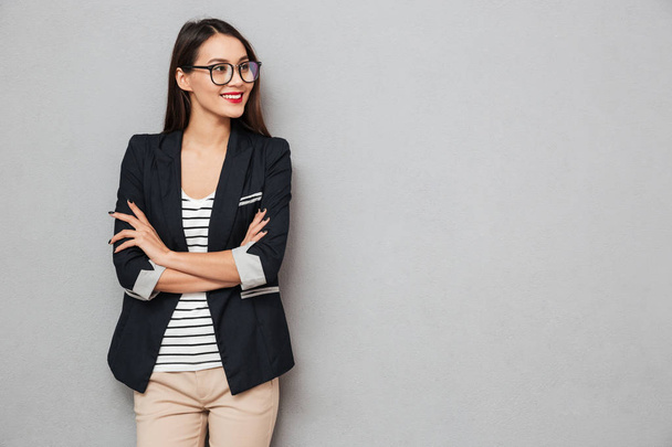 Smiling business woman in eyeglasses with crossed arms looking away - Foto, Imagen