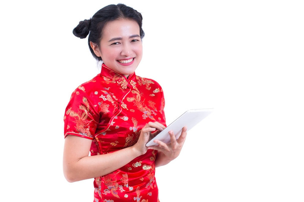 Krásná mladá asijská žena nosí tradiční cheongsam čínských šatů nebo QIPa. Ruce drží a přenosném počítači. Online nakupování. Koncept nákupu digitální online. Ruka se dotýká tabletu, sociální média. - Fotografie, Obrázek
