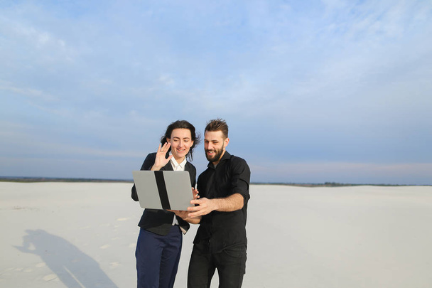 Журналисты мужчина и женщина используют ноутбук для подготовки репортажа на
 - Фото, изображение