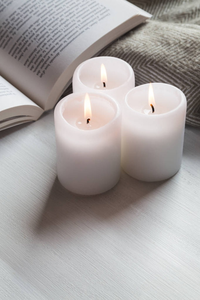 Candles and book with cozy blanket - Фото, изображение
