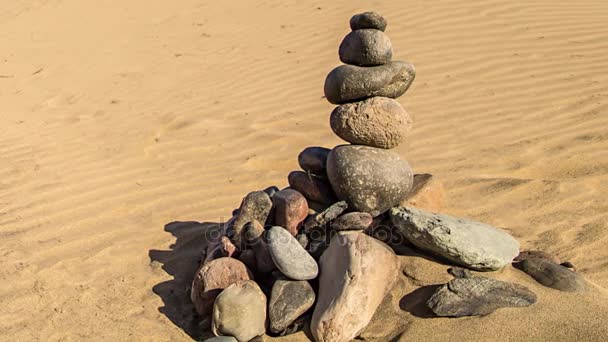 Pirâmide de rocha zen de pedras coloridas. Conceito de equilíbrio, harmonia e meditação, construído sobre areia do mar
 - Filmagem, Vídeo