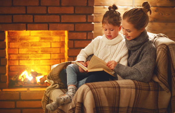 glückliche Familie Mutter und Tochter lesen Buch über Winter eveni - Foto, Bild