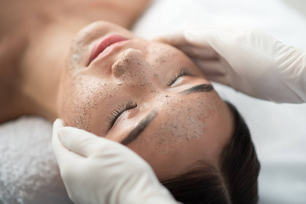 Beautician applying scrub on female face - Fotografie, Obrázek