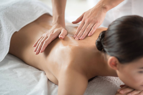 Skillful beautician doing massage for relaxed girl - Foto, Imagem