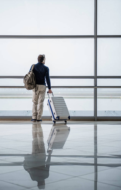 Ajattelevainen mies kuuntelemassa musiikkia lentokentällä
 - Valokuva, kuva