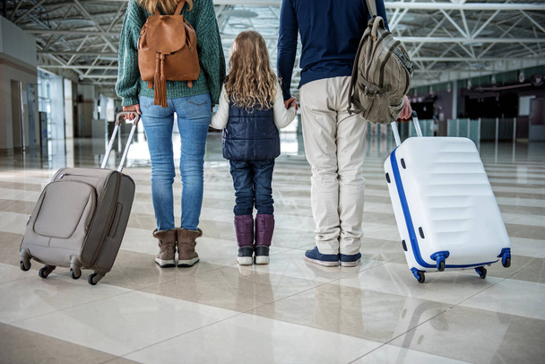 Parents and child holding cases after plane landing - Foto, Bild
