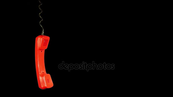 Swinging in the air bright red old rotary telephone handset hanging isolated against black background illustrate lost connection or other problem concept. Copy space for your text. - Footage, Video
