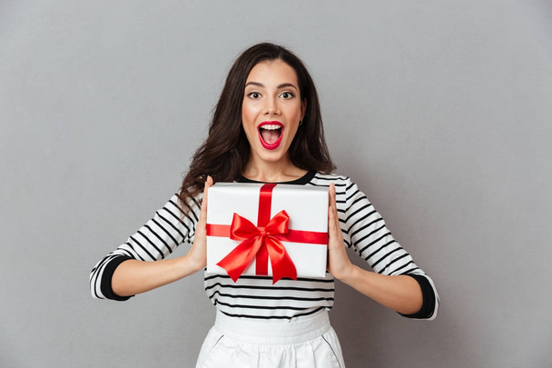 Portrait of a happy girl holding present box - Фото, изображение